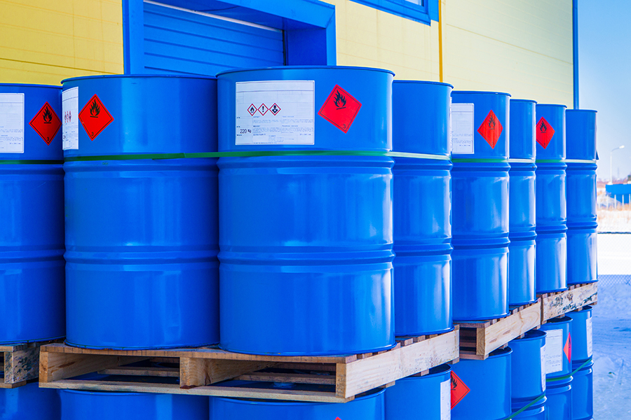GHS-compliant chemical drum labels on industrial blue barrels